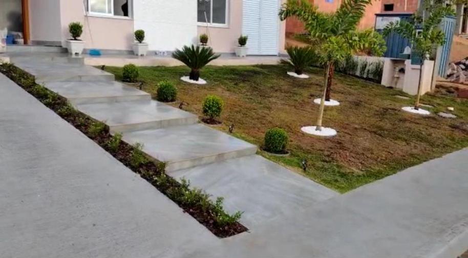 Acesso com degraus, buxinhos e palmeiras recém-plantadas