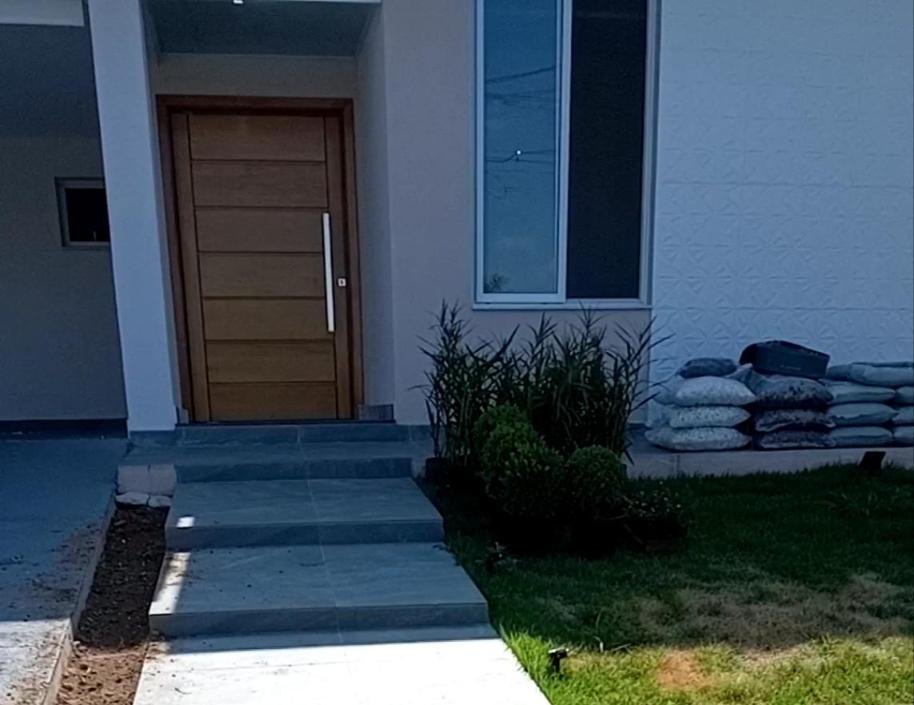 Entrada residencial com gramado e maciço de plantas